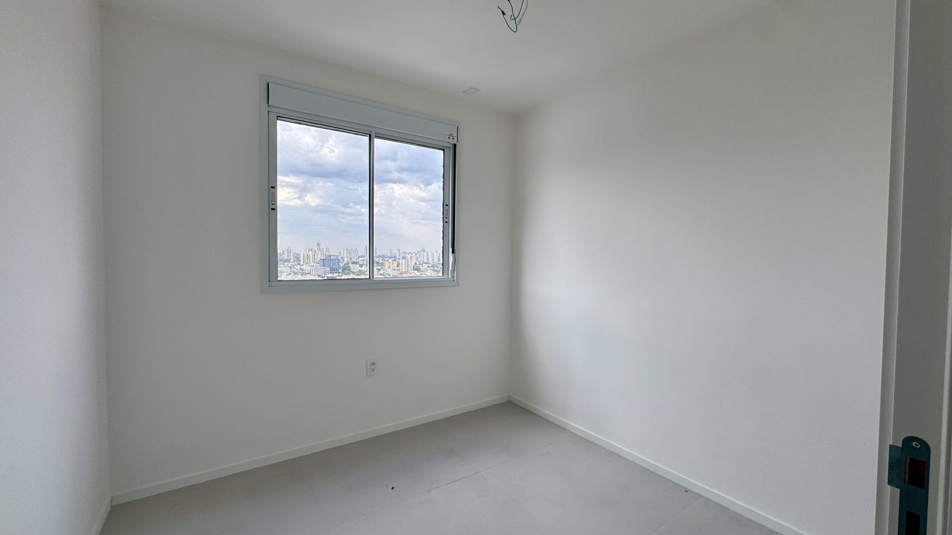 Quarto com janela ampla e vista da cidade